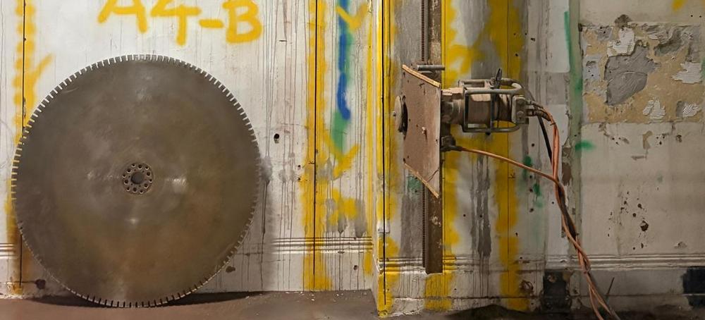 Diamond wall saw blade positioned against a marked-up concrete wall ahead of cutting.